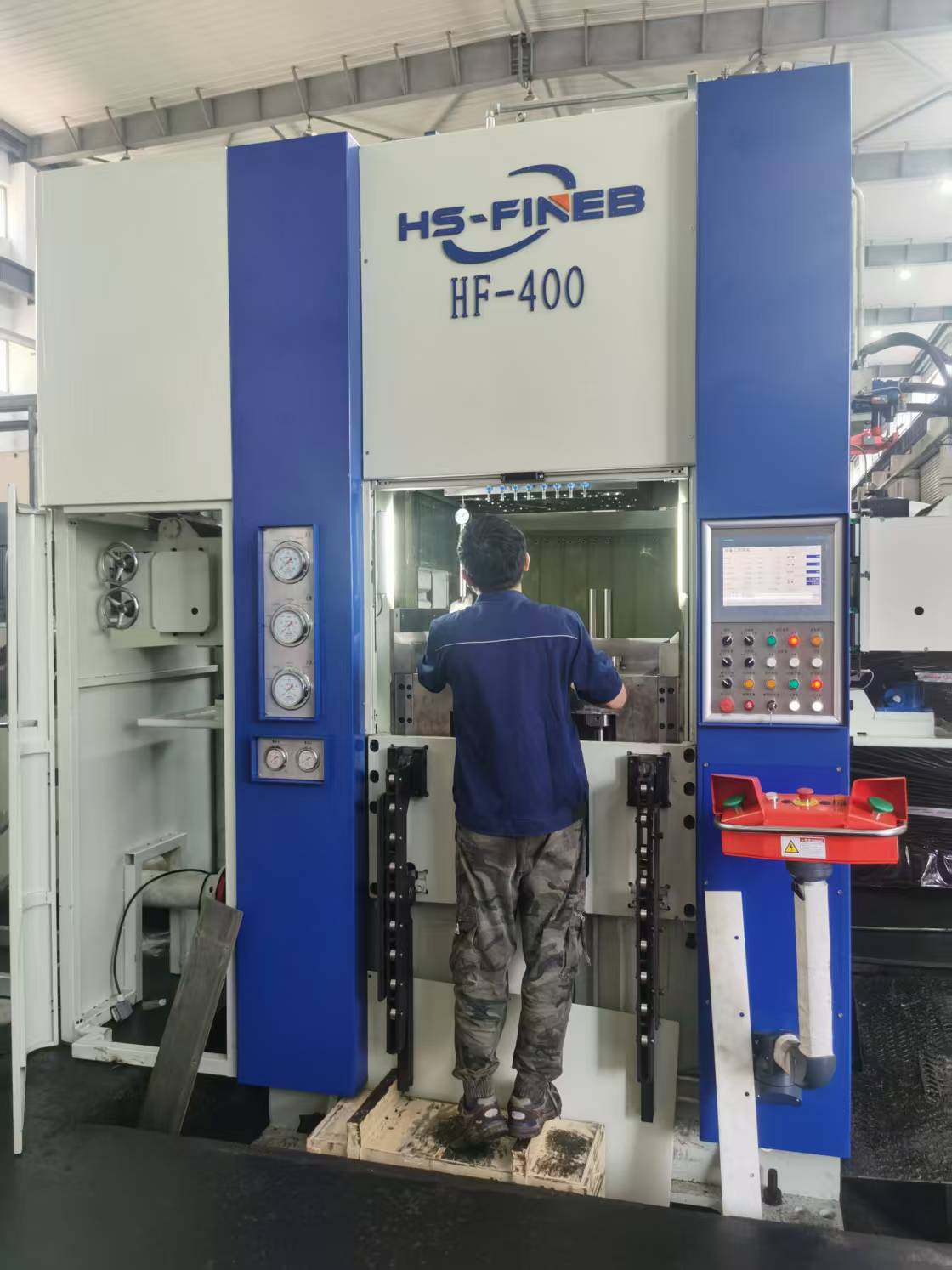 HS-FINEB HF-400 fine blanking press with technician performing die maintenance at control panel